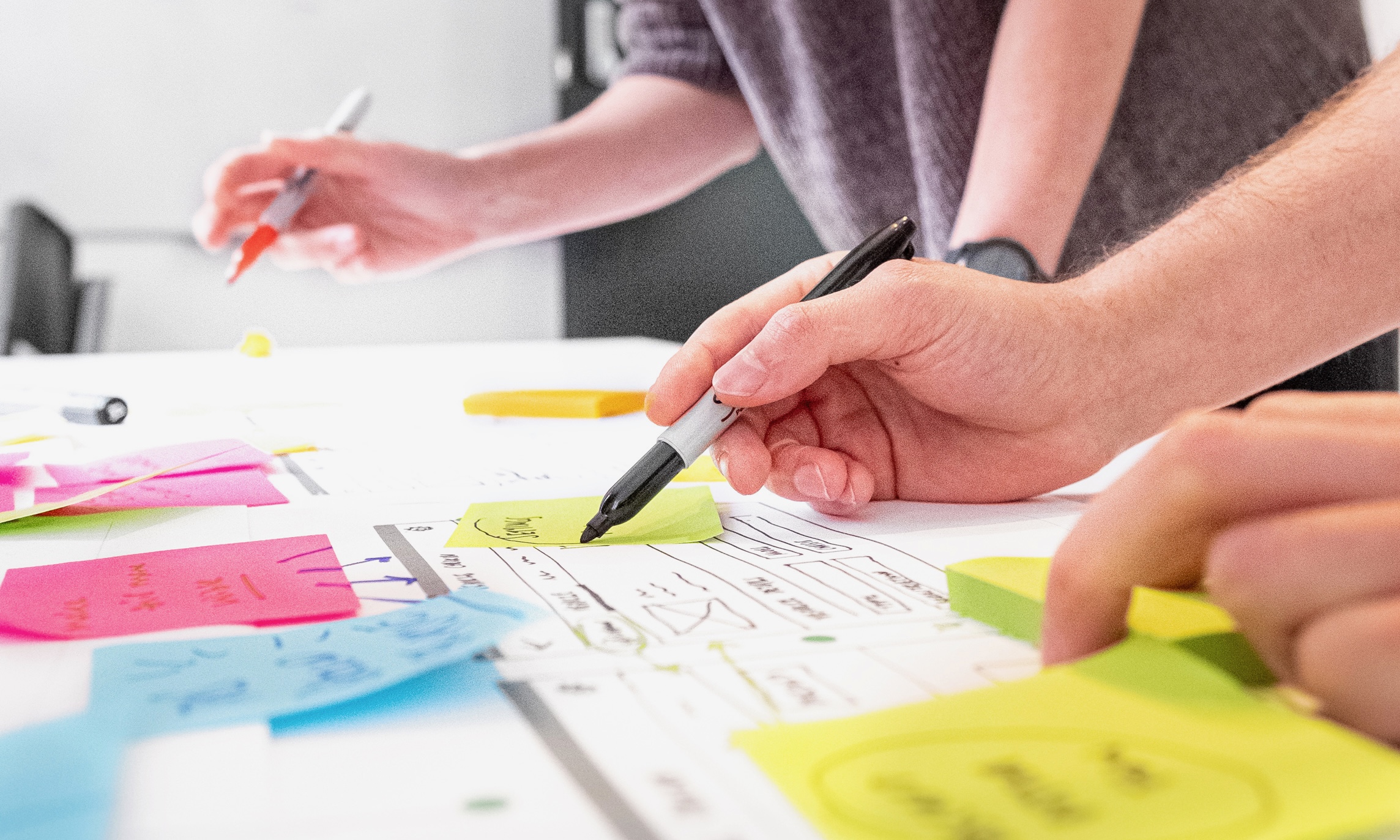 People stood over a table looking at design ideas