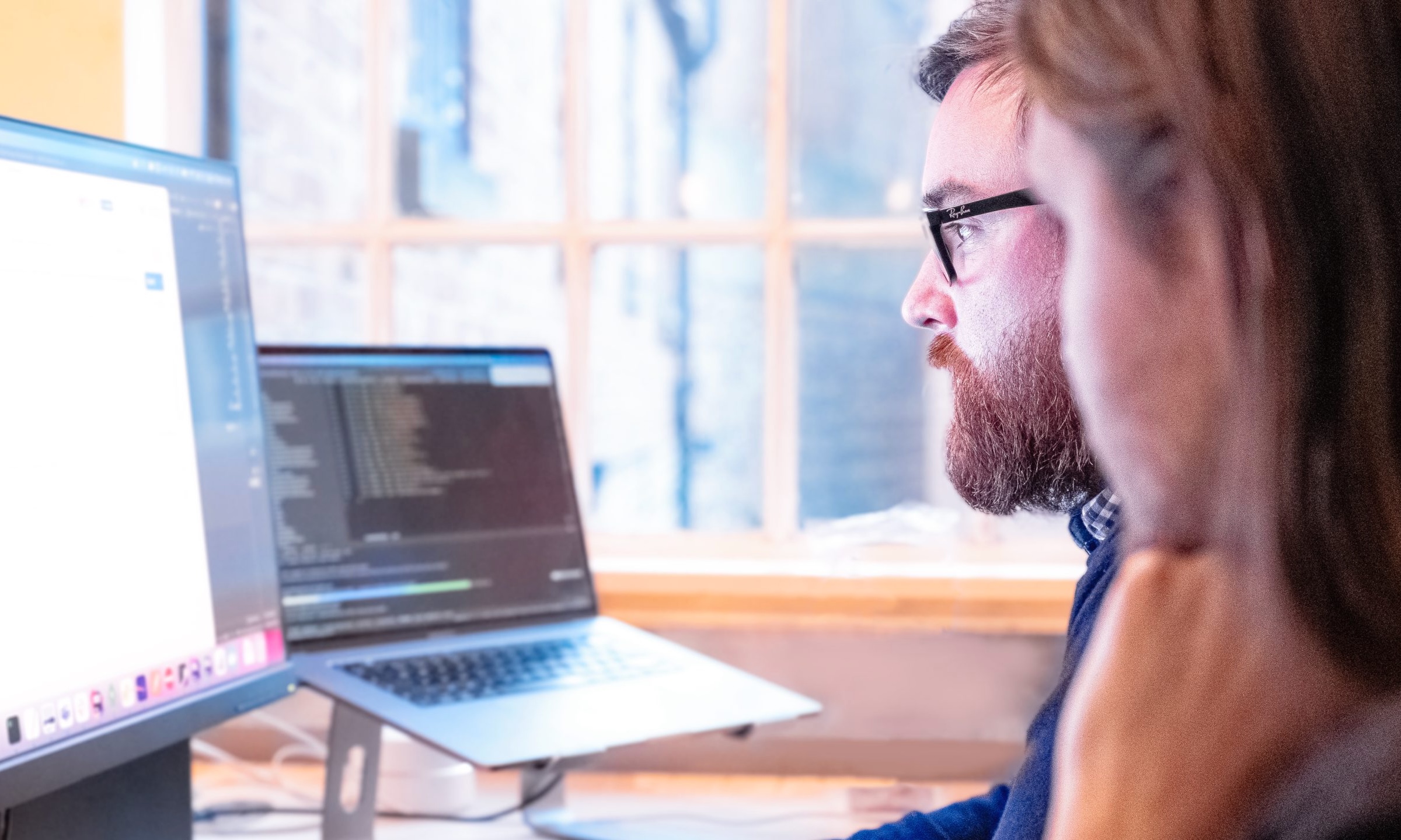 Two people looking at a computer screen with code on it