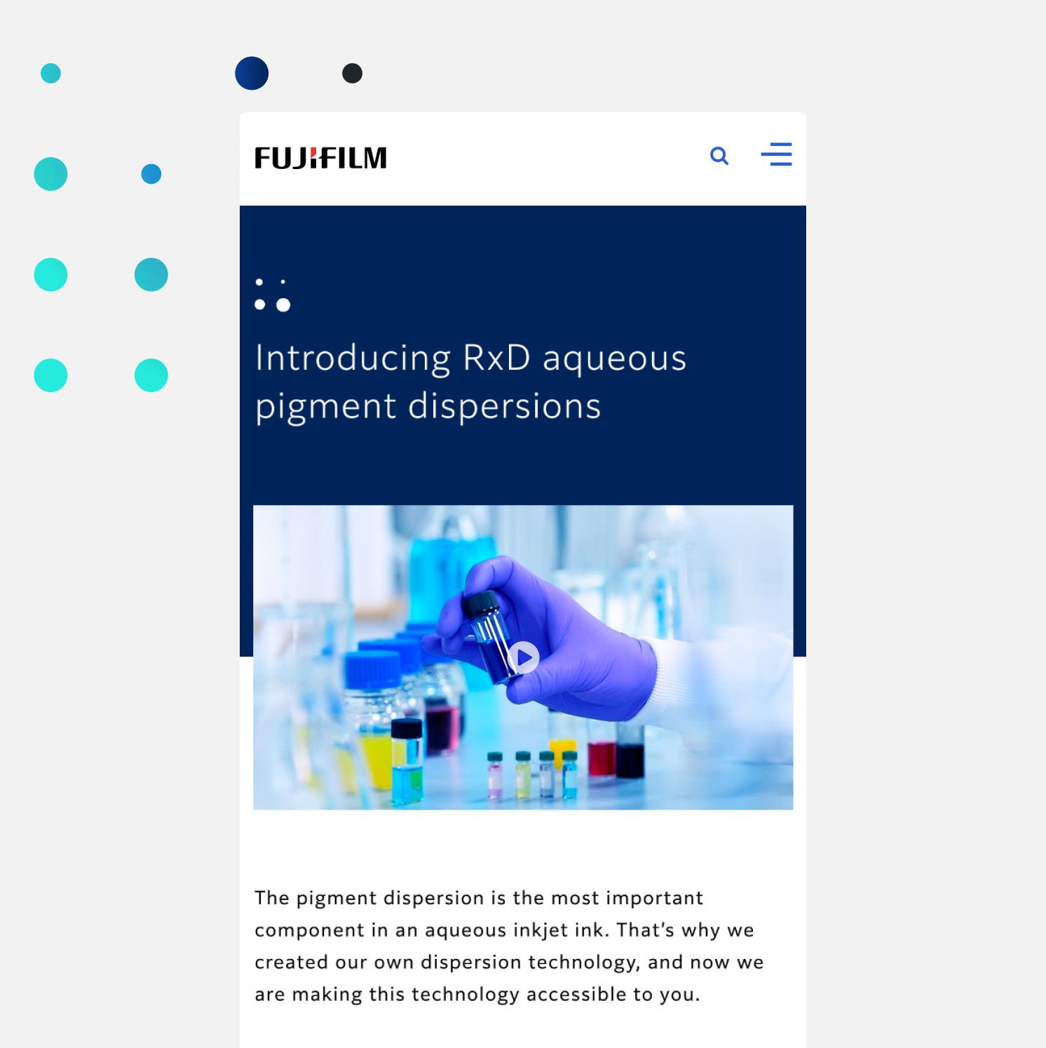 A gloved hand holds a vial of blue liquid above a lab table with test tubes and bottles, on a Fujifilm webpage introducing RxD aqueous pigment dispersions.